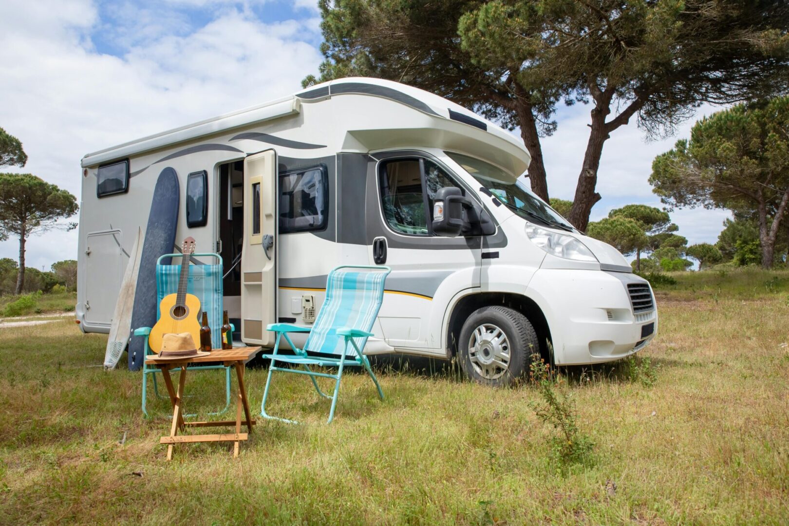 pexels-kampus-production-7967392 A white rv parked in the grass near trees.